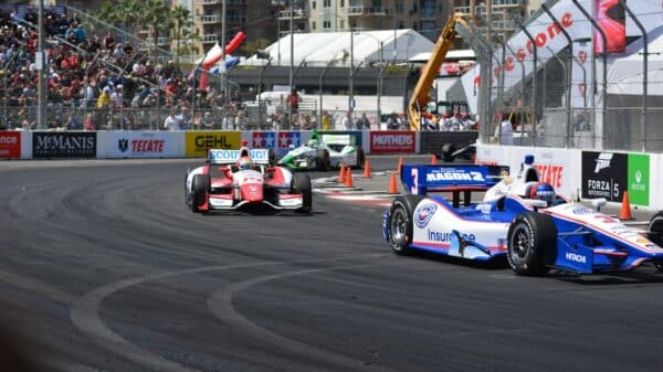 a group of racing cars driving down a race track