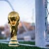a golden soccer trophy sitting on top of a soccer field