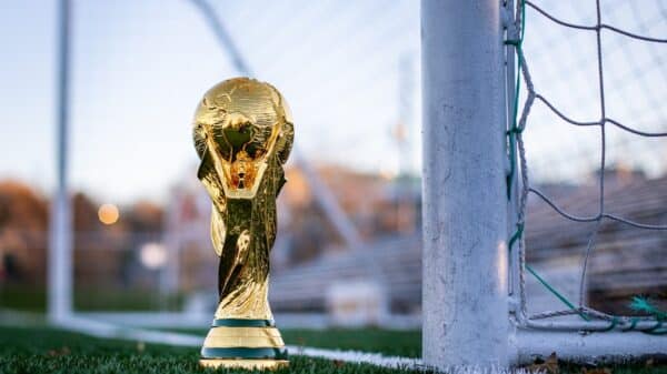 a golden soccer trophy sitting on top of a soccer field