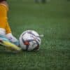a person kicking a soccer ball on a field