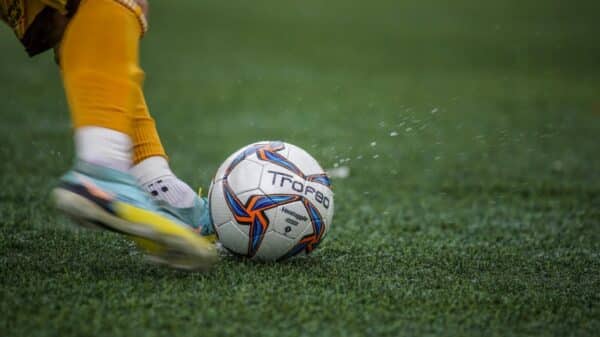 a person kicking a soccer ball on a field