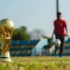 selective focus photography of gold-colored trophy on grass field during daytime