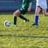 a couple of kids playing a game of soccer