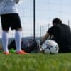 man in black t-shirt and white shorts playing soccer during daytime