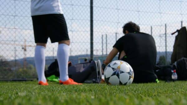 man in black t-shirt and white shorts playing soccer during daytime